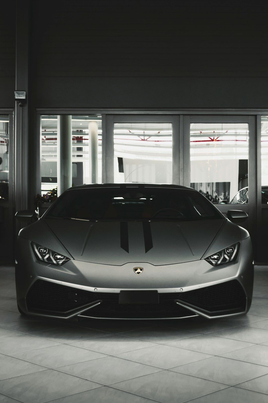 Elegant dark showroom interior displaying several luxury exotic cars